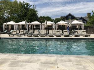 a swimming pool with lounge chairs and umbrellas at White Elephant Hotel in Nantucket