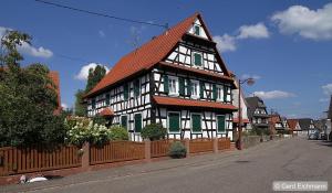 um grande edifício preto e branco com persianas verdes em Belle Chambre Privée - Sdb - cuisine partagée - Wifi - Jardin em Wissembourg