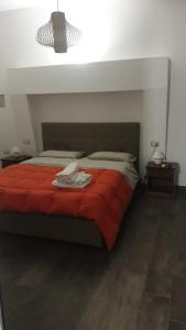 ein Schlafzimmer mit einem Bett mit einer roten Decke in der Unterkunft Le Volte Apartments in Torchiarolo