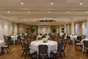 une salle de banquet avec des tables et des chaises ainsi qu'un lustre dans l'établissement White Elephant Hotel, à Nantucket
