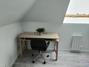 a wooden desk with a chair and a plant on it at Les Lofts De Provins: Apt 6 in Provins +3 photos