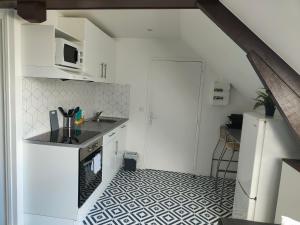 a kitchen with white cabinets and a black and white floor at Les Lofts De Provins: Apt 6 in Provins