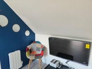 a living room with a tv and a chair and a chair at Les Lofts De Provins: Apt 6 in Provins