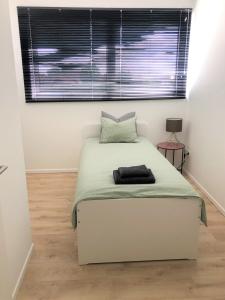 Dormitorio pequeño con cama y ventana en Domum en Dilsen-Stokkem