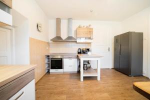 a kitchen with a refrigerator and a table in it at Holiday house Vedle in Desná