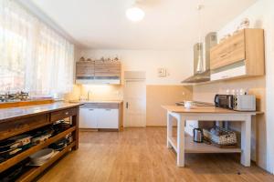 a kitchen with wooden floors and a counter with a table at Holiday house Vedle in Desná