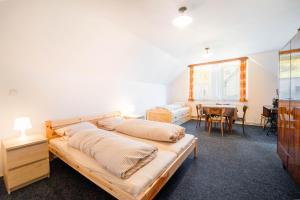 a bedroom with two beds and a dining room at Holiday house Vedle in Desná