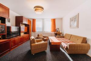 a living room with a couch and chairs and a television at Holiday house Vedle in Desná