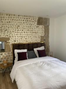 a bedroom with a large bed with a stone wall at Domaine de Maeva in Romans-sur-Isère