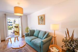 ein Wohnzimmer mit einem blauen Sofa und einem Tisch in der Unterkunft 188 Apartments - Lantana - pool, garden and patio in Cascais