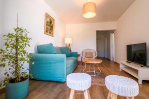 a living room with a blue couch and a tv at 188 Apartments - Lantana - pool, garden and patio in Cascais