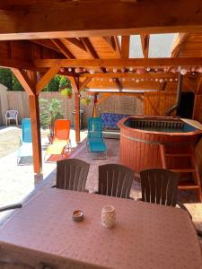 a table and chairs under a wooden pergola at Mató Vendégház in Bogács