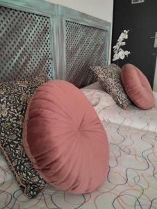 a bed with a large pink pillow on it at Céntrico piso con aparcamiento in Granada