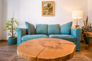 ein Wohnzimmer mit einem blauen Sofa und einem Couchtisch aus Holz in der Unterkunft 188 Apartments - Lantana - pool, garden and patio in Cascais