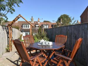 a wooden table and chairs on a patio at Bay Cottage in Cayton