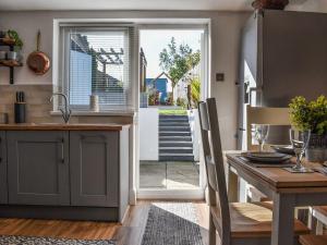 a kitchen with a table and a door to a patio at Bay Cottage in Cayton