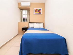 Cama en habitación con manta azul en Hotel Trianon, en Veracruz