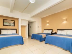 2 camas en una habitación con sábanas azules en Hotel Trianon, en Veracruz