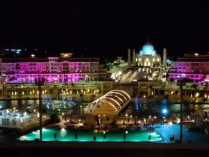 Porto Sharm hosts & apartments في شرم الشيخ: إطلالة على مدينة في الليل مع أضواء أرجوانية