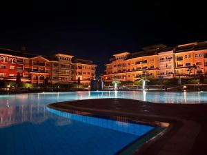 Porto Sharm hosts & apartments في شرم الشيخ: مسبح كبير أمام المباني في الليل