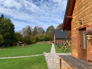 a wooden building with a bench next to a yard at Dwernik Bukowina Bieszczady in Dwernik