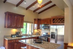 a kitchen with wooden cabinets and a granite counter top at Placencia Pointe Townhomes #7 in Placencia