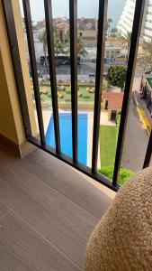 Pokój z widokiem na basen przez okno w obiekcie Don Gustavo Modern Apartment, Sea Views & Pool w mieście Benalmádena