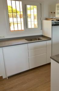 kuchnia z białymi szafkami i zlewem w obiekcie Don Gustavo Modern Apartment, Sea Views & Pool w mieście Benalmádena