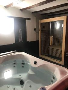 La salle de bains est pourvue d'une baignoire et d'une fenêtre. dans l'établissement Casa Wellness Floreffe jacuzzi, à Floreffe