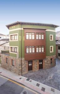 a large building on the side of a street at Apartamentos El Aramo Asturias in Pola de Lena
