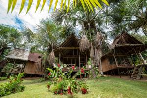 a resort with palm trees in front of a building at Pacaya Samiria Amazon Lodge - ALL INCLUSIVE in Nauta