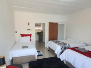 une chambre d'hôtel avec deux lits et une chambre avec dans l'établissement Casa Línda Guest House, à Newcastle