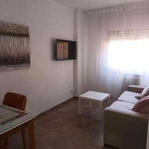 - un salon avec un canapé et une table dans l'établissement Piso en el centro de Granada con garaje incluido gratis, à Grenade