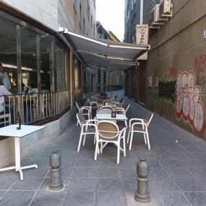 - une rangée de tables et de chaises à l'extérieur d'un restaurant dans l'établissement Piso en el centro de Granada con garaje incluido gratis, à Grenade
