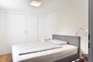 a bedroom with a bed with white sheets and a lamp at Ferienwohnung Spreeblick in Alter Graben
