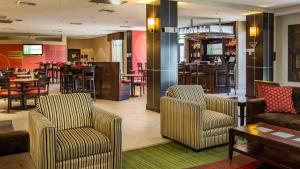 a restaurant with chairs and tables and a bar at Holiday Inn Oklahoma City Airport, an IHG Hotel in Oklahoma City