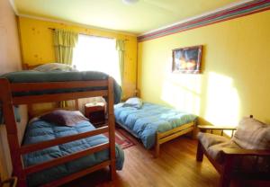 a bedroom with two bunk beds and a window at Hospedaje Independencia y camping in Punta Arenas
