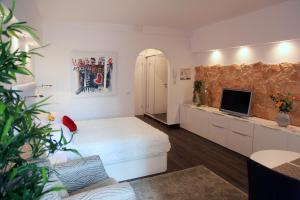 a bedroom with a white bed and a tv and a couch at La Perla in Puerto de la Cruz