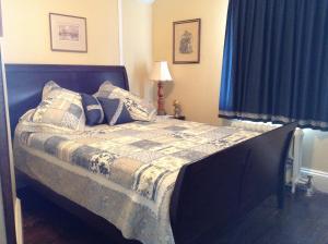 a bed in a bedroom with a blue curtain at Gil Ann in Saint-André-Avellin