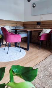 Habitación con escritorio y 2 sillas rosas. en Entspannung pur mit DaheimGefühl, en Baiersbronn