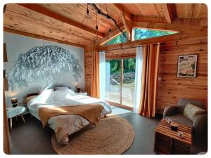 um quarto com uma cama grande e uma janela grande em Chalet, bain nordique (spa) dans le triangle noir em Quissac