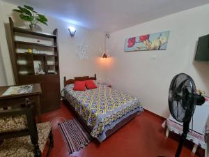 um quarto com uma cama e uma ventoinha em Mi lugar Vintage Hostal - calor de hogar! em Assunção