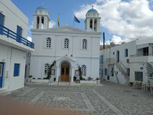 a white church with two towers on a street at Panorama in Parikia
