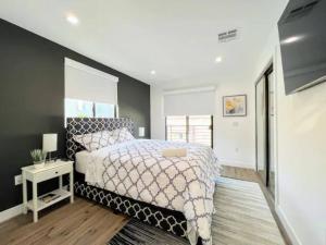 a bedroom with a bed with a white bedspread and a table at 4BR Townhouse in KoreaTown in Los Angeles