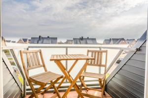 two chairs and a table on a balcony at Westbrise App 7 in Wenningstedt