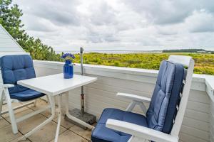 un tavolo e due sedie su un balcone con vista sull'oceano di Traumblick App 4 a Munkmarsch
