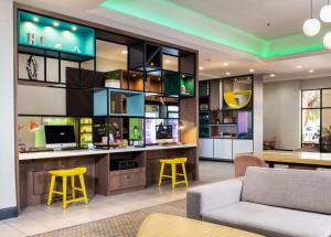 uma sala de estar com dois bancos amarelos num quarto em Holiday Inn & Suites Phoenix-Mesa-Chandler, an IHG Hotel em Mesa