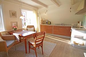 una cucina con tavolo in legno e una sala da pranzo di App Anne a Süderende