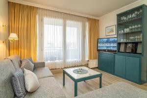 un soggiorno con un divano e una TV di App Störtebeker App 16 a Westerland