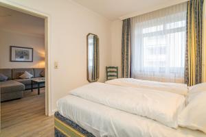 una camera da letto con un grande letto bianco e una finestra di App Störtebeker App 16 a Westerland